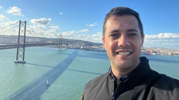 Fernando Cattelan Cordeiro em Portugal, com fundo céu azul e mar