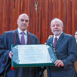 Foto de Alexandre de Moraes à esquerda e Lula à direita, segurando diploma de presidente.