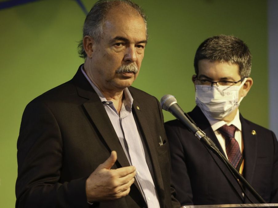 Foto do presidente do BNDES Aloizio Mercadante ao lado do senador Randolfe Rodrigues. Mercadante veste uma camisa azul listrada enquanto Randolfe usa gravata vinho e palitó preto