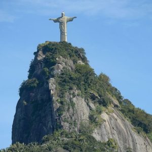 Foto do Cristo Redentor, um dos principais cartões postais do turismo no Brasil, tirada durante o dia.