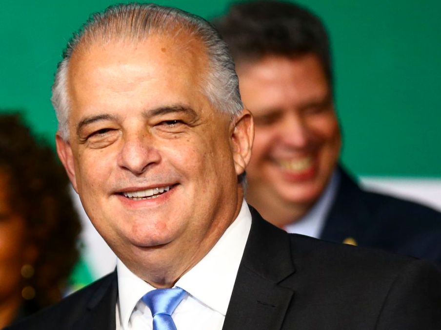 Foto do ministro de Portos e Aeroportos, Márcio França. Ele é homem, tem cabelos grisalhos e usa um terno preto e gravata azul-clara