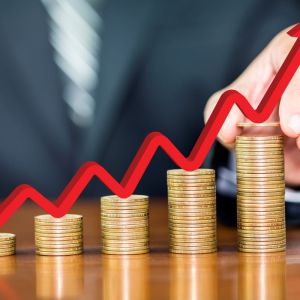 Imagem para a matéria sobre ROIC em que um homem cria uma sequência crescente de pilhas de moedas com uma seta que indica crescimento.