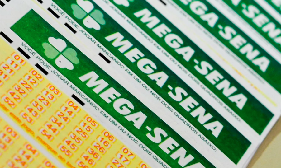 Foto de diversos bilhetes de apostas de mega-sena. Eles possuem os números em amarelo e um escrito "mega-sena" em verde.