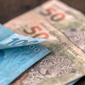 Foto de duas notas de 50 reais, junto com uma nota de 100 reais.