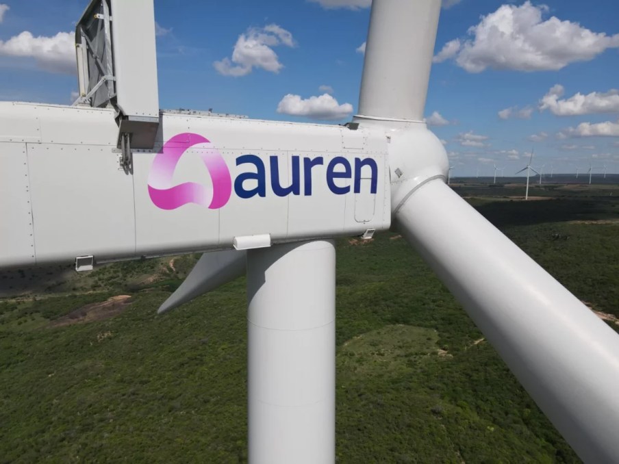 Foto de turbina eólica eólico da Auren Energia durante um pôr-do-Sol. A matéria é sobre ações da Auren (AURE3) de energia que são sensíveis a Selic, como Equatorial (EQTL3), Neoenergia (NEOE3) e Energisa (ENGI11)