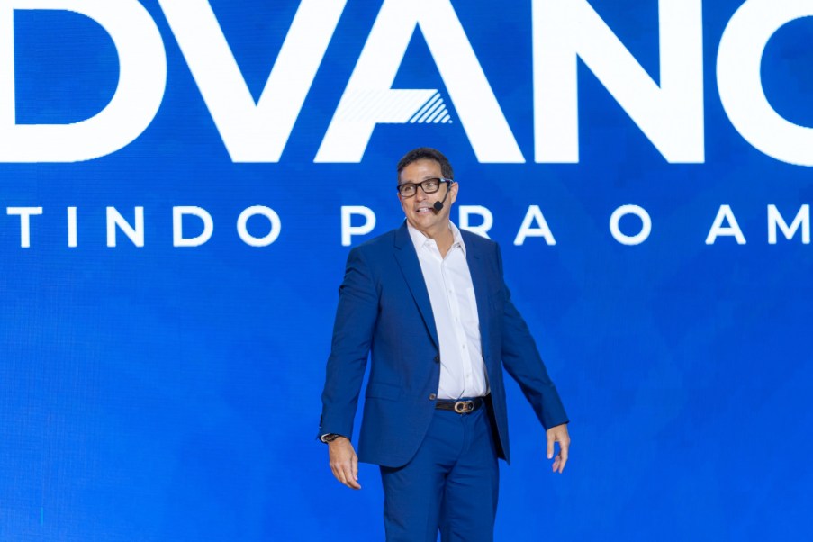 Foto de Roberto Campos Neto, economista e ex-presidente do banco Central. Ele é homem, usa terno azul e fala ao microfone sobre tarifas de Trump e risco de estaginflação no Brasil